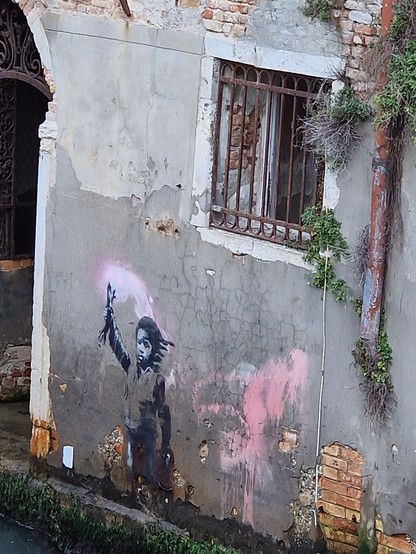 A mural of Banksy, a child holding a wooden stick as torch. It has a pink colour smoke. The child shows and triggers all kinds of emotions, like sadness, glory, stubborness, fragile, determination, ...