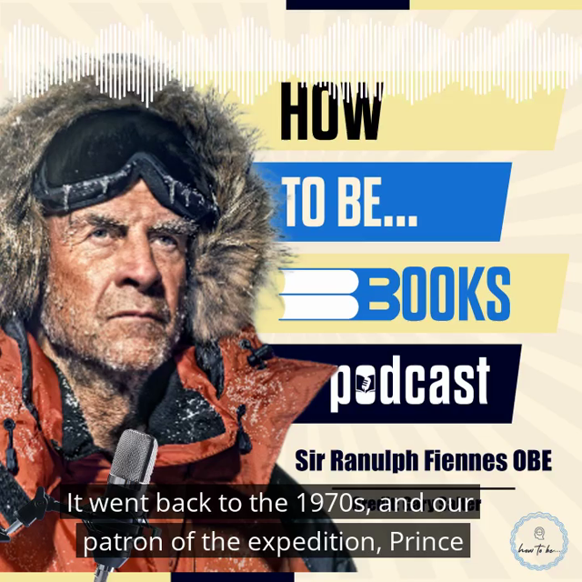 Sir Ranulph Fiennes wears an orange thermal ski jacket with hood up and covered in ice and snow. He stands behind a microphone with a yellow, blue and beige background that says How To Be Books Podcast.