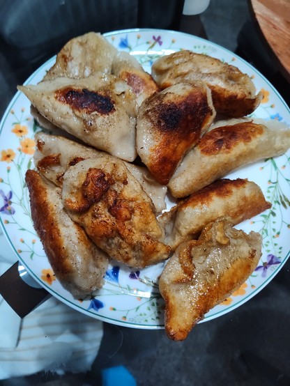 An attempt at homemade potstickers on a floral plate. They're not pretty,  but they're tasty!