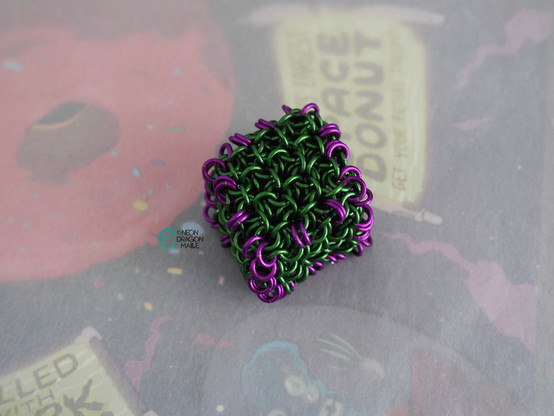 a chainmaille jelly cube in green with purple borders to look like a gelatinous cube creature from dungeons and dragons