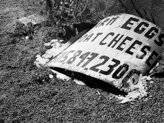 A decaying sign that reads “Farm Eggs, Goat Cheese.”