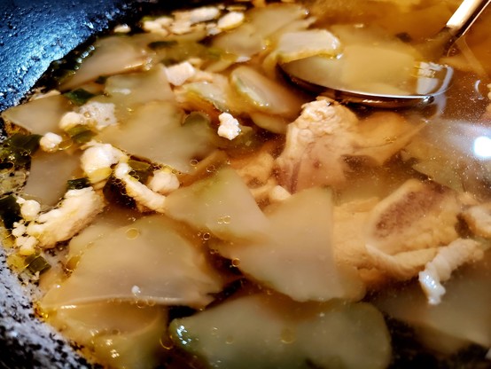 Pickled mustard & pork soup in a wok.