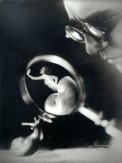 A man with glasses, and a snail, both looking at a woman emerging from a snail shell under a magnifying glass.
