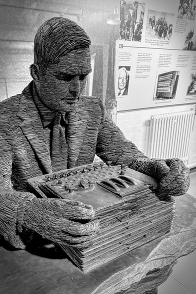 Black and white photo of the Stephen Kettle slate sculpture of Alan Turing at Bletchley Park