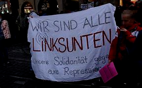 weißer Banner bei einem Protest 
Beschriftung:

"Wir sind alle Linksunten - Unsere Solidarität gegen eure Repression"