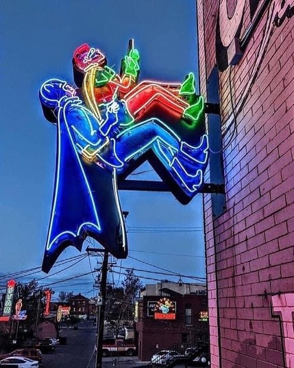 A neon sign of Batman and Robin climbing the wall like they did in the 1960's TV show
