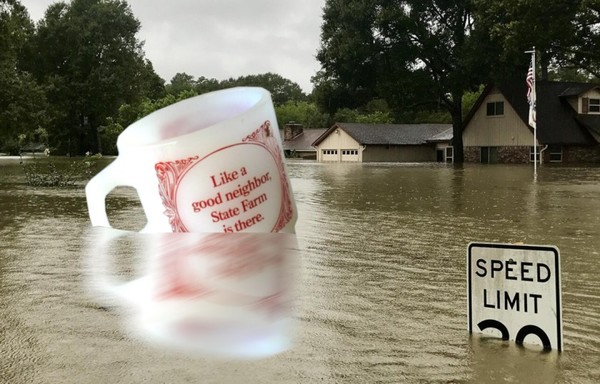A flooded suburban street with water up to the roofline of the houses in the background. In the foreground floats a giant mug emblazoned 'Like a good neighbor, State Farm is there.'