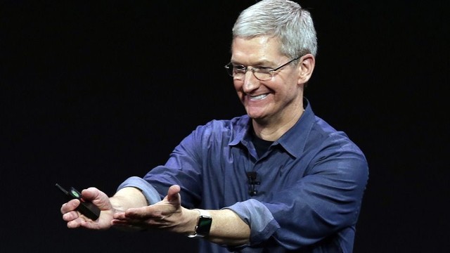 publicly recognize people: a photograph of Apple's Tim Cook on stage, grinning and stretching out his hands toward the audience