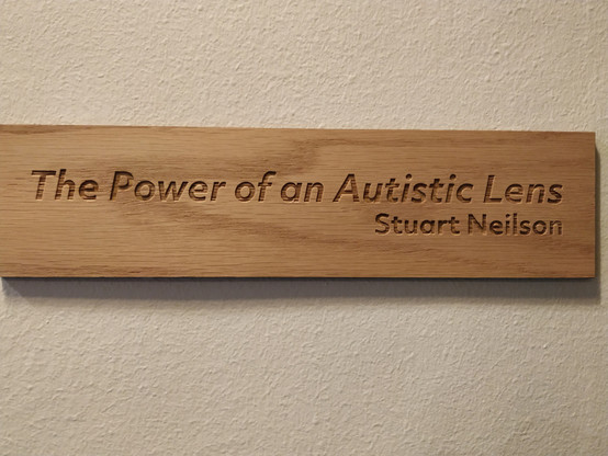 A discreet little caption with the title "The Power of an Autistic Lens" adjacent to the vinyl wall transfer.