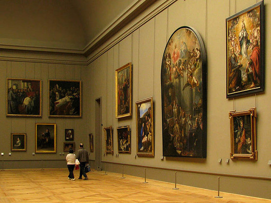 RIP Conference Curator: photograph of two people walking in a high-ceiling art museum with large paintings on the walls