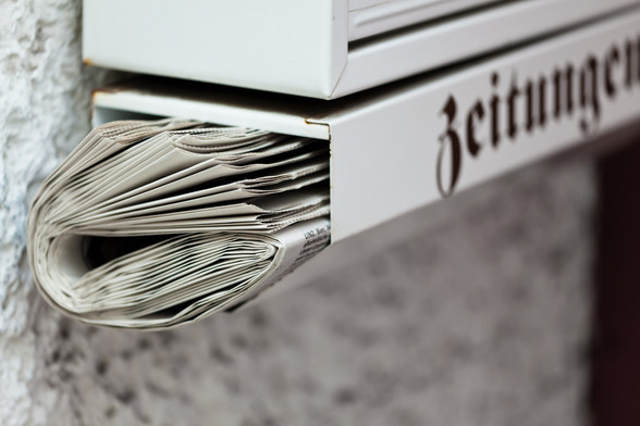 A newspaper tucked into a part of a letterbox marked 'Zeitungen'. Image by Lisa S via Shutterstock.
