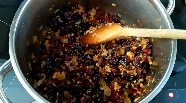 In a large stainless steel pan, assorted fruits, nuts and spices are combined over a low heat. Next: a good helping of Port...