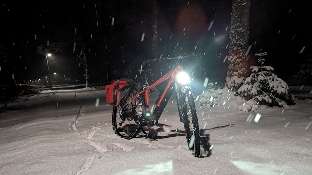 Ein rotes Raleigh Dundee Mountain Bike von vorn auf einem schneebedecktem Radweg.
