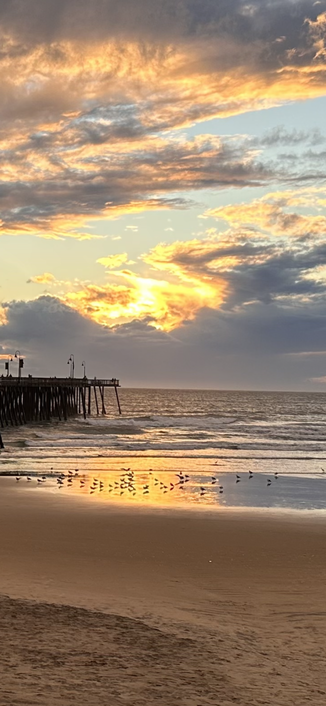 Orange and red colors of a setting sun reflecting on Pacific