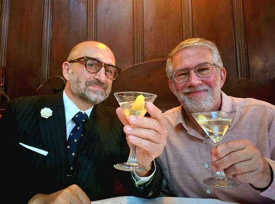 Mat and Bill, two middle-aged white bearded gentlemen, toasting the camera with martini's at a table at LA's FAMOUS Musso & Frank's. BECAUSE WE FANCY.