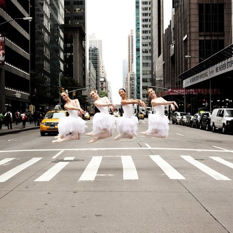 4 danseuses de danse classique en tenue en train de sauter sur un passage piÃ©ton d'une grande avenue Ã  NY,
photo de Lisa Tomasetti