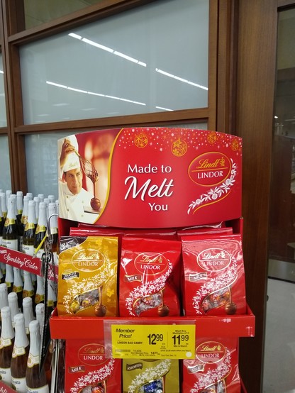 A Lindt Lindor chocolate display featuring a photo of a chef in a white toque creating a chocolate dessert, with the slogan "Made to Melt You" alongside