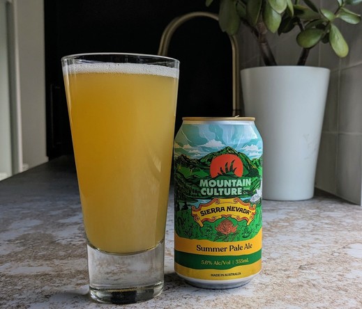 A glass of hazy summer beer next to a can