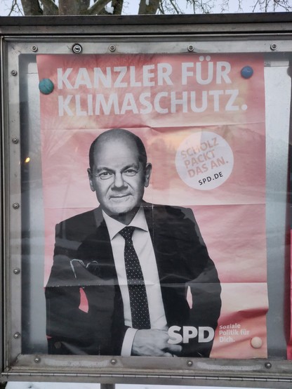 Plakat mit Olaf Scholz und den Schriftzügen "Kanzler für Klimaschutz" und "Scholz packt das an".