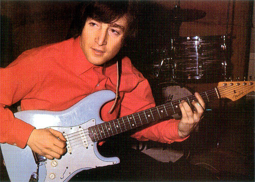 John Lennon wearing a red shirt playing a Sonic blue fender Stratocaster.