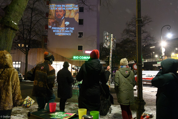 Aktivist*innen von Extinction Rebellion projizieren Nachrichten an eine Häuserfassade in Kreuzberg. Berlin, 02.12.2023