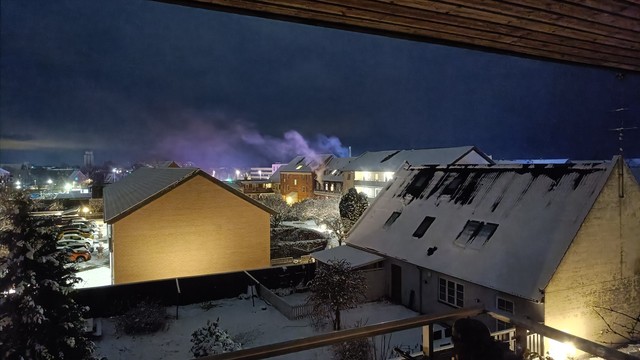 byhus hvor der vælter røg ud af vinduet, røgen et oplyst af de blå blink fra redningskøretøjer