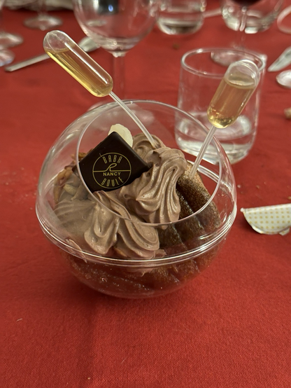Un baba au rhum dans une coque de présentation en plastique