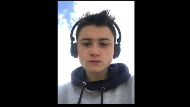 Photo of Arlo, a trans man with short hair and headphones