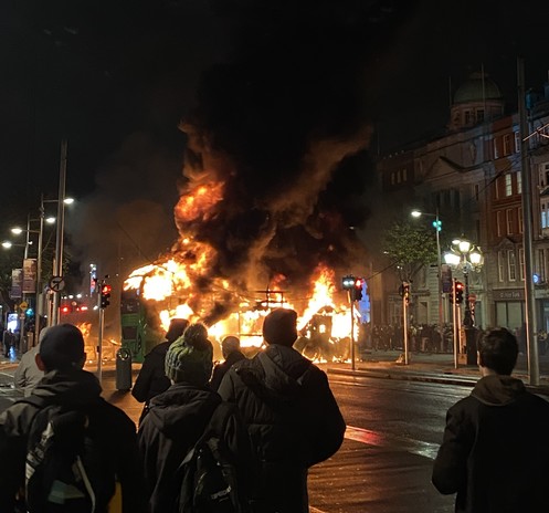 Dubliners watch as a Dublin Bus is engulfed in flames during the 2023 Dublin riot. Photograph taken from O'Connell Bridge, facing northwards towards O'Connell Street.

Source: CanalEnthusiast