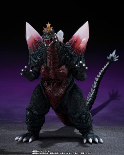 a photo of an action figure of SpaceGodzilla, he is similarly shaped to godzilla but has two large pink crystals coming out of each shoulder and clear crystals at the end of his tail and a star-shaped crown crest formation on his head