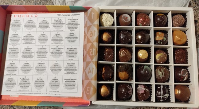An image showing a Chococo advent box with a selection of 25 chocolates. To the left, the contents list from the box, listing the order & description of each day's chocolate. To the right, the advent box before we started eating.