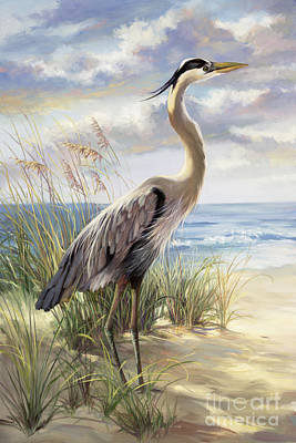 Painting of a large blue and white coloured heron standing on a light brown beach with lots of groups of tall mainly green coloured grass around it. In the background is the light blue ocean. The sky is coloured in shades of blue as well as white, with many white clouds with a lot of blue and yellow touches on them.