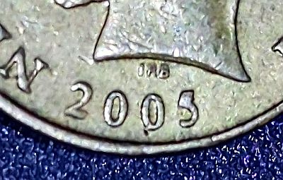 Closeup of the date on the 2005 NZ dollar coin showing the die break with the partly filled top on the 5