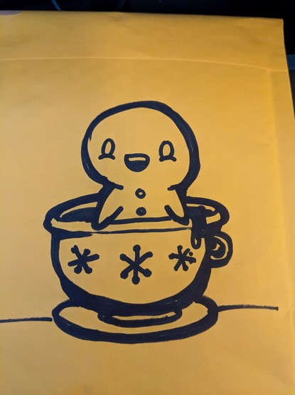 Black marker sketch of a gingerbread man in a teacup.
