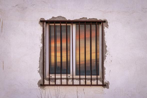 Se puede ver un cielo al atardecer reflejado en una ventana.

You can see a sunset sky reflected in a window.