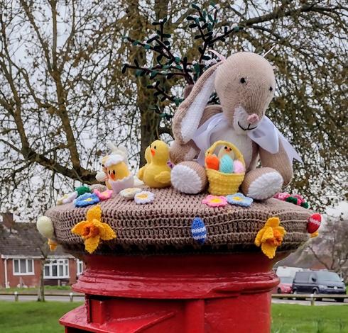 A kitted Easter themed topper on a postbox.