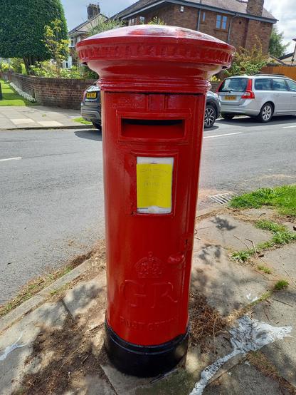 A red GR postbox on the corner of the pavement. It has a handwritten warning on yellow paper: CAUTION WET PAINT

I touched the paint. It was dry.