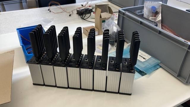 8 V2X Nodes in metal boxes. Each box has 6 antennas in a row sticking out.