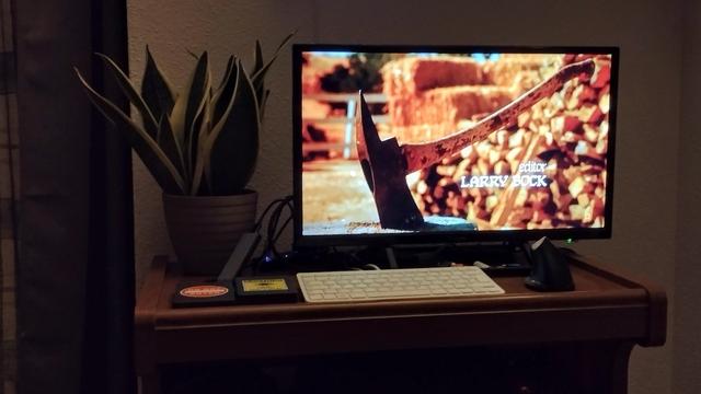 Mesa con una planta y un televisor.en la que sale la escena inicial de una película.