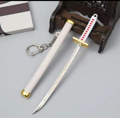 An ornate miniature sword with a white sheath and decorative grip, displayed alongside a wooden stand.