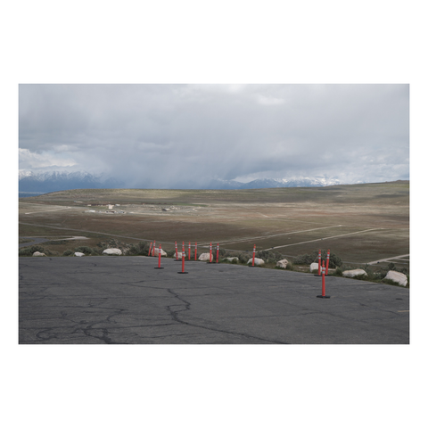 Looking out from a parking lot with a group of safety cones that's high above the valley below