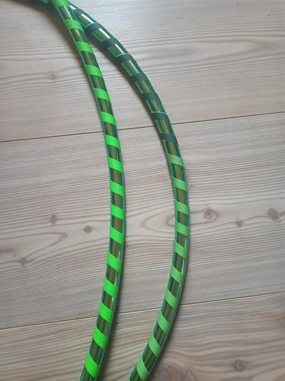 Grüner Glitzerhoop auf hellem Holzboden