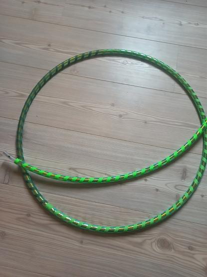 Grüner Glitzerhoop auf hellem Holzboden