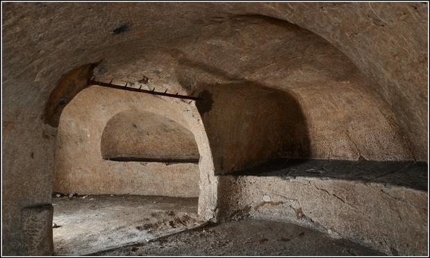 Deux alcôves creusées dans la masse de craie, séparées par une arche.
Au ciel, des crocs de bouchers.