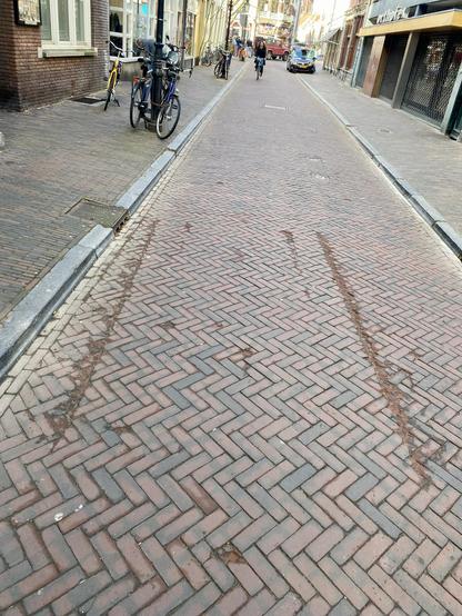 Two lines of damaged brick. About the same distance apart as a car axel.