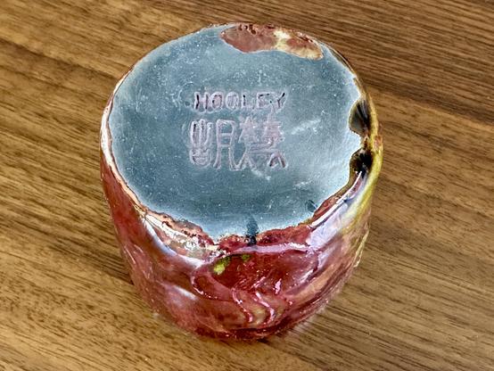 View of the bottom of the cup, which is mostly charged black from the carbonization. You can see my maker mark in the center, which has been filled in with red underglaze and now has a very dark brick-like appearance.