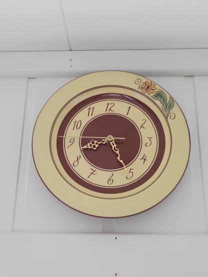 The wall clock in the shape of a plate shows 0825 (it's 5 min fast)