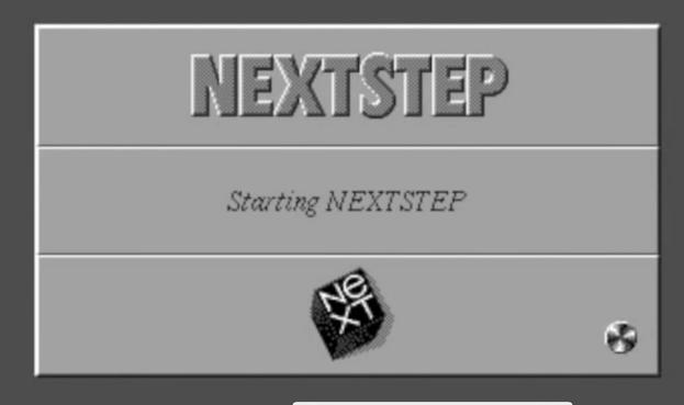 NEXTSTEP OS loading screen showing spinning magento-optical mouse pointer icon indicating that the system is busy