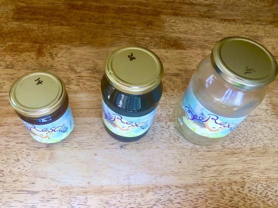 Honey jars. Two on the left full, one on the right empty.