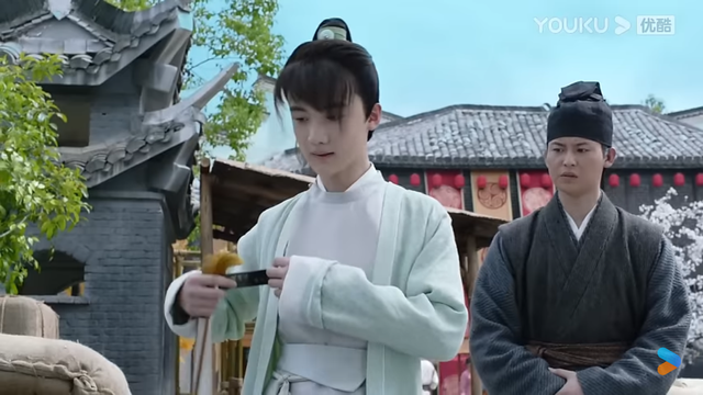 Chengling holding out an invitation to zzs while servant looks on in disapproval
